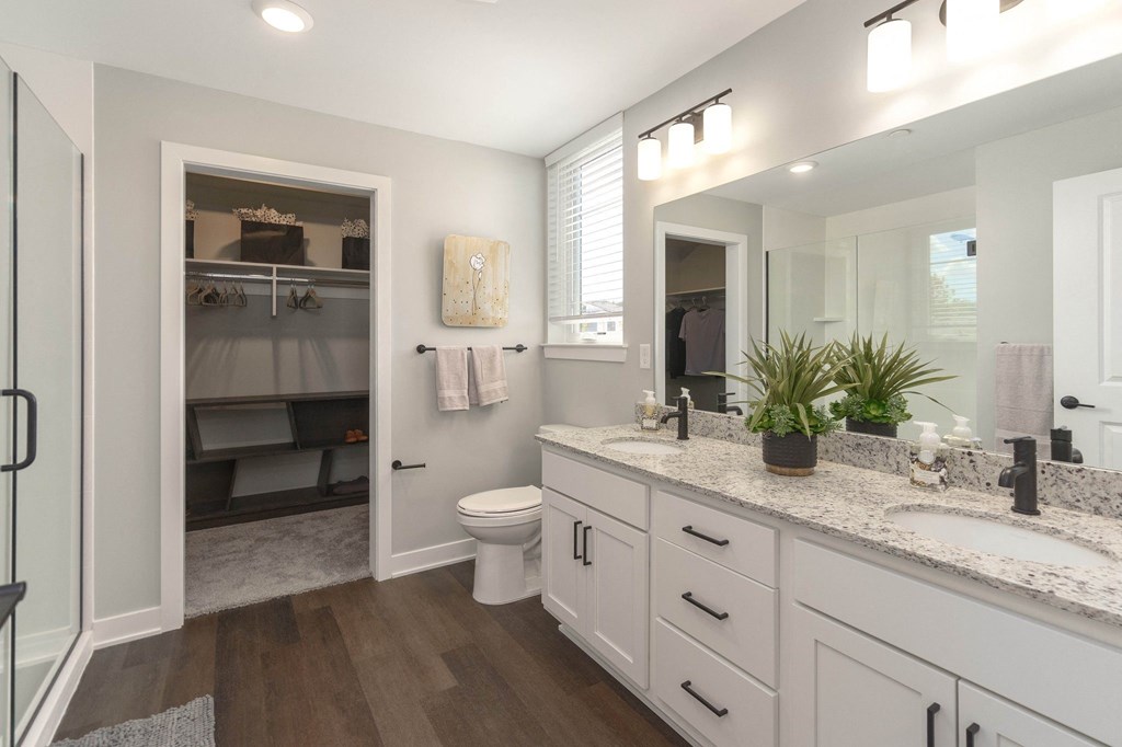 a bathroom with white cabinets and a white toilet and a sink